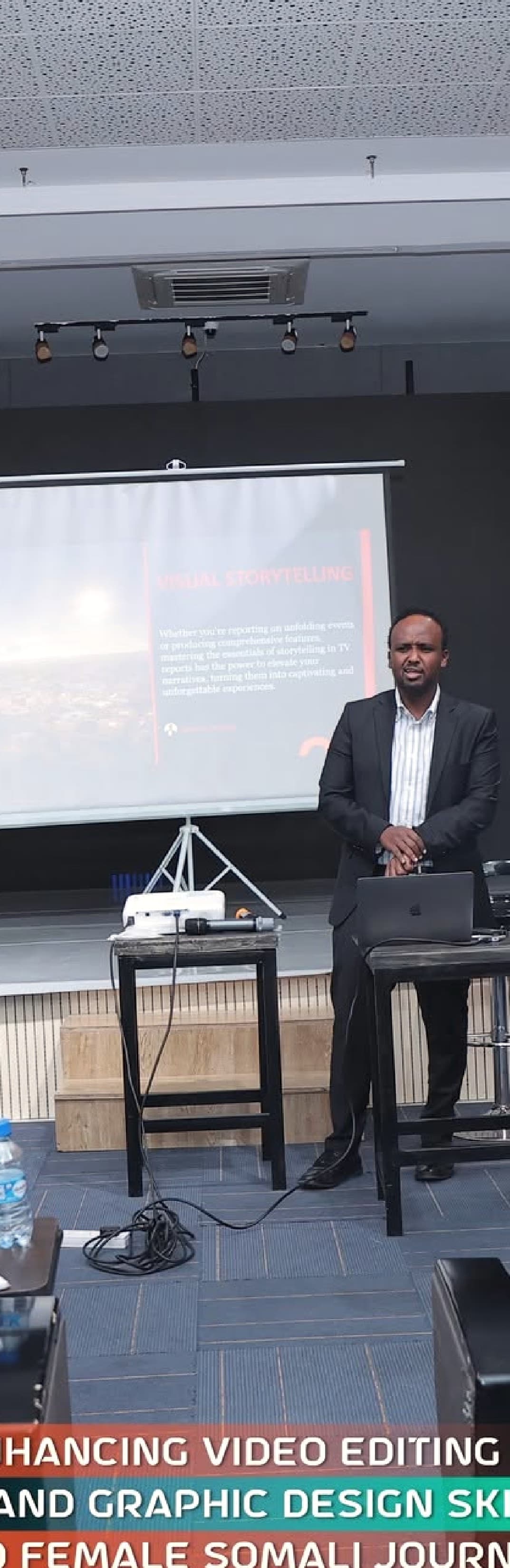 A trainer presents on stage in the Astaan Academy screening room during a creators session